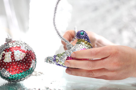Woman performs Christmas tree ornaments. Styrofoam balls decorated with colorful sequinsの写真素材