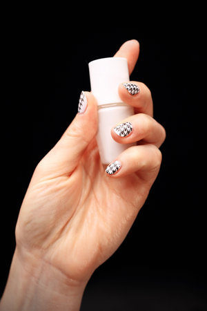 Woman's hand with fingernails painted in black and white checkeredの写真素材