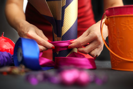 Woman packs a Christmas gift and decorating the house with Christmas decorationsの写真素材