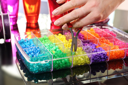 Colorful beads. The woman Creates jewelry with colored plastic beads
