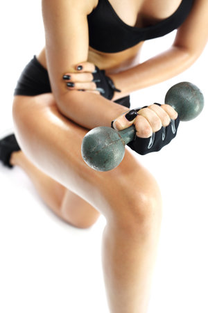 Woman in sports attire raises the weights.の写真素材