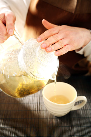The waitress pours tea into a cup.の写真素材