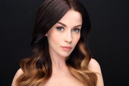 Portrait of a beautiful woman with long hair on a black background