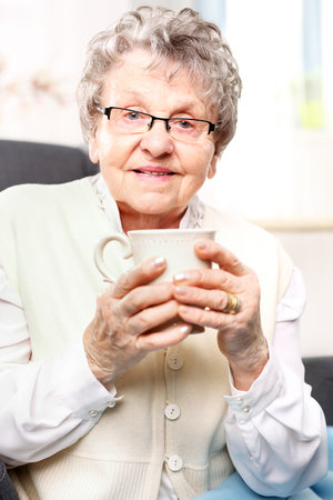 old lady drinking a brew of herbsの写真素材