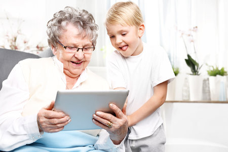 Grandmother with grandson playing on the tablet.の写真素材