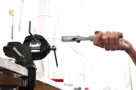 Jeweler's workshop, vise and pliers, the artist at work.の写真素材