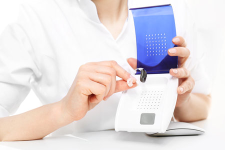 Dryer care of hearing aids. Audiologist shows how to use the dryer for hearing aidsの写真素材