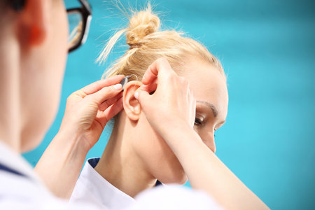 Inserting your hearing instruments. The doctor assumes the woman hearing aid in your earの写真素材