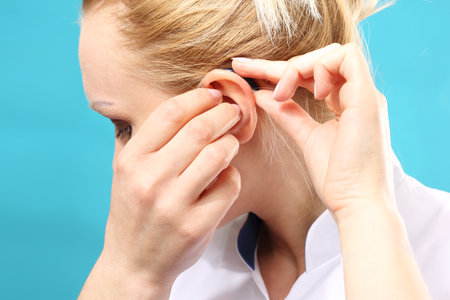 Hearing aid. The doctor assumes the woman hearing aid in your earの写真素材