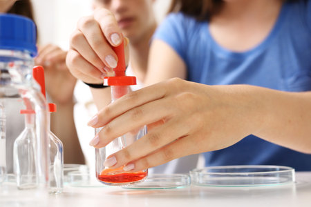 Schoolgirl performs chemical experience.