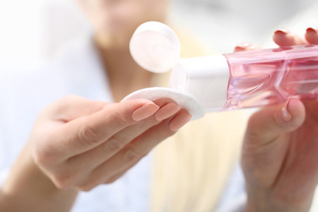 Make-up removal. The woman pours a tonic on a cotton pad.の写真素材
