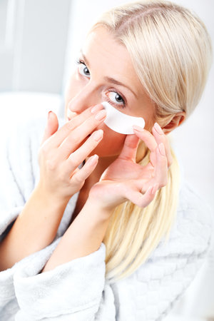 Petal collagen eye, a way to smooth skin. Portrait of a beautiful young woman with collagen mask around the eyeの写真素材