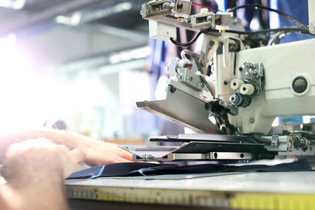 Sewing machine. The production plant, sewing clothes by seamstresses on the sewing machineの写真素材
