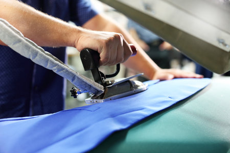 Ironing professional. Presser in sewing clothes pressed.の写真素材