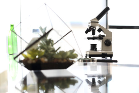 Workshop laboratory microscope stands on a glass countertopの写真素材