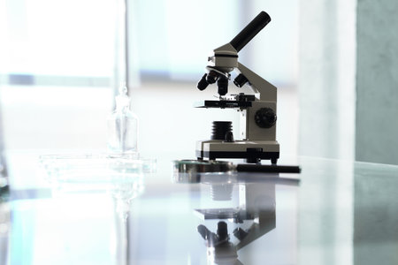 Microscope. Workshop laboratory microscope stands on a glass countertop