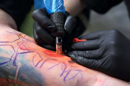 Tattoo machine. Tattooer tattooing color tattoo on his hand manの写真素材
