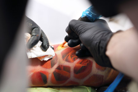 Tattoo machine. Tattooer tattooing color tattoo on his hand manの写真素材