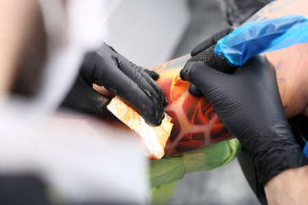 Tattoo machine. Tattooer tattooing color tattoo on his hand manの写真素材