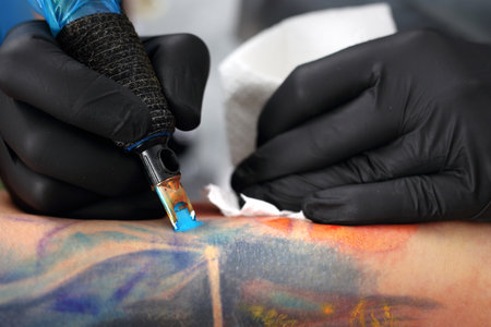 tattoo. A tattoo artist disinfects the customer a new drawing on the skin. Securing tattoo stretch filmの写真素材