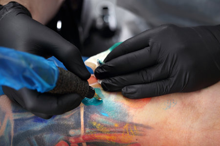 Tattoo machine. Tattooer tattooing color tattoo on his hand manの写真素材