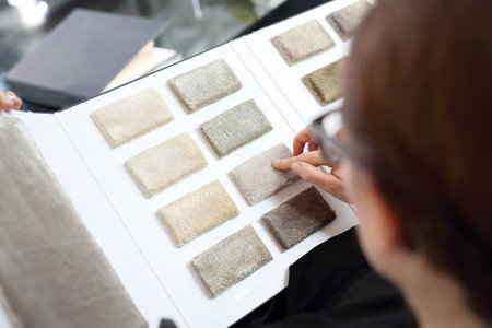 Woman in shop with carpets chooses carpet probe