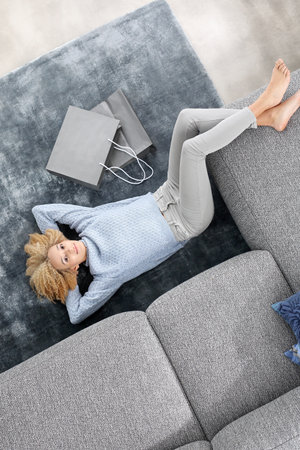 Relaxation, leisure. Woman relaxing on the carpet.の写真素材