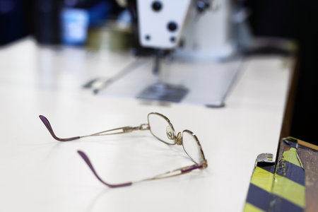 Glasses to work. Glasses left by a seamstress at the sewing machineの写真素材
