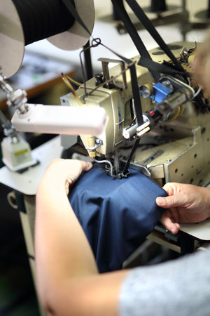 Production of clothes, sewing on a machine. The production plant, sewing clothes by seamstresses on the sewing machineの写真素材