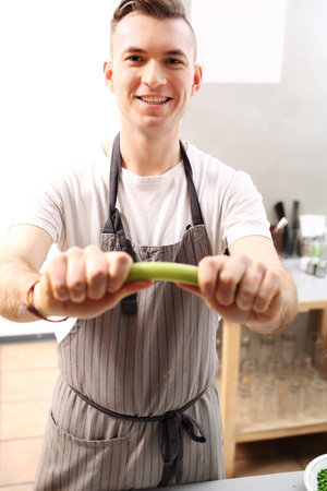 Celery in the kitchen. The cook holds in his hand a vegetable.の写真素材