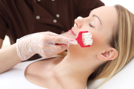 Skin care, massage the facial skin. Female beautician, massage your face.の写真素材