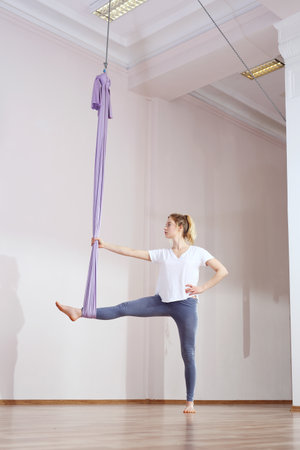 Yoga air. Yoga on the horn. A woman is practicing yoga on a hose, aerial yogaの写真素材