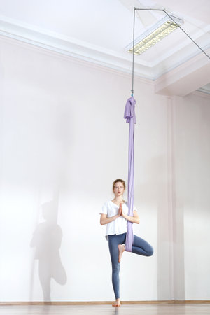 A woman is practicing yoga on a hose, aerial yogaの写真素材