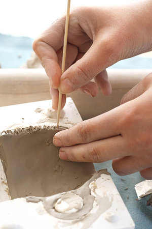 Ceramic workshop. Woman sticks to a clay.