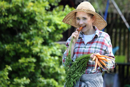 Healthy diet. Gardener carrot in the garden.の写真素材
