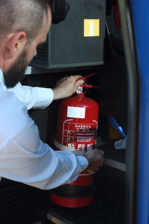 Car fire extinguisher. The bus driver shows the fire extinguisher during the inspection