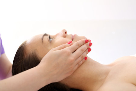 Face massage Woman in beauty parlor during facial massage.の写真素材