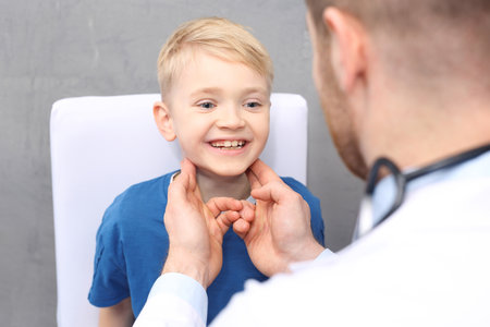 Medical examination. The pediatrician checks the lymph nodes on the boy's neckの写真素材