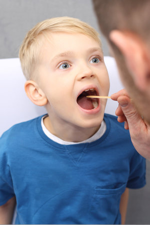 Sick child to the doctor. The pediatrician checks the boy's gardの写真素材