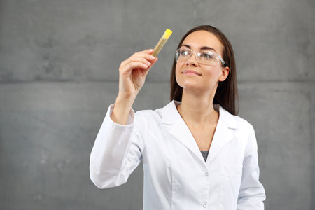 Medical laboratory. The laborer assesses the color of urineの写真素材
