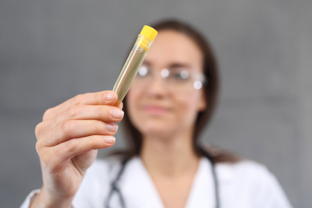 Urine test. A young laboratory woman holding a test tube with a urine sampleの写真素材