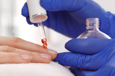 Nourishing oil applied to the skin at the nails. Manicure, beautiful and well-groomed female hands.の写真素材