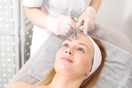 Acne and skin problems. Oxygen infusion. A woman in a beauty salon during a care treatment using active oxygenの写真素材