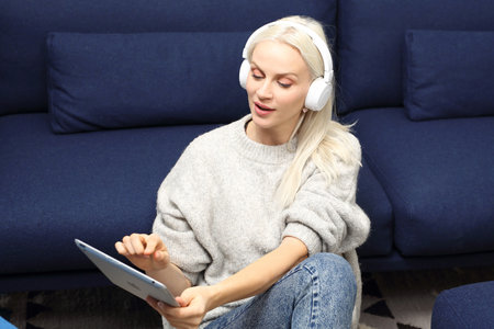 Audiobook. The woman listens to the recording on the headphones.の写真素材