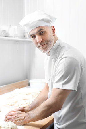 Confectionery. The man knead the dough.の写真素材