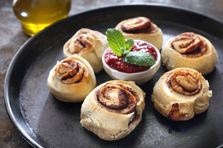 Sweet pastries. Cinnamon rolls with raspberry sauce.の写真素材