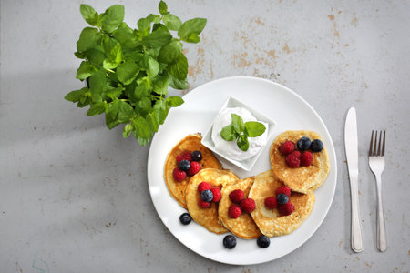 Fruit pancakes. A portion of tasty pancakes with berries, served with yoghurt sauceの写真素材