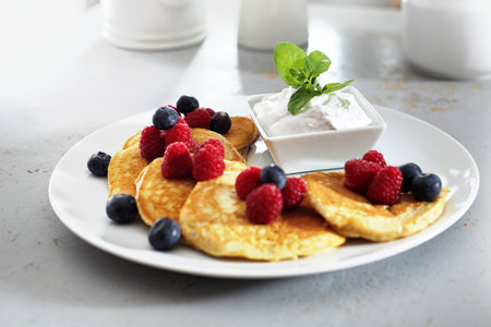 Fluffy pancakes with summer fruits. A portion of tasty pancakes with berries, served with yoghurt sauceの写真素材