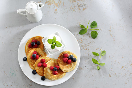Pancakes, diet pancakes with fruit. A portion of tasty pancakes with berries, served with yoghurt sauceの写真素材