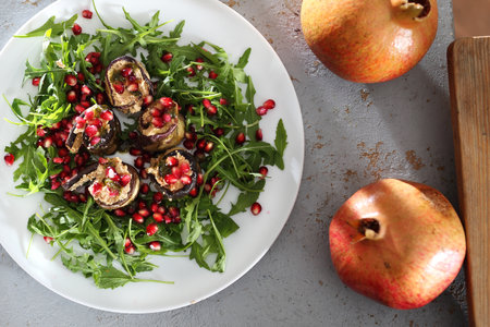 Appetizer. Eggplant roulades with cheese served with pomegranate on rocket lettuce.の写真素材